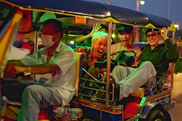 Tourists preparing for a night tuk-tuk ride through Bangkok’s lively streets.